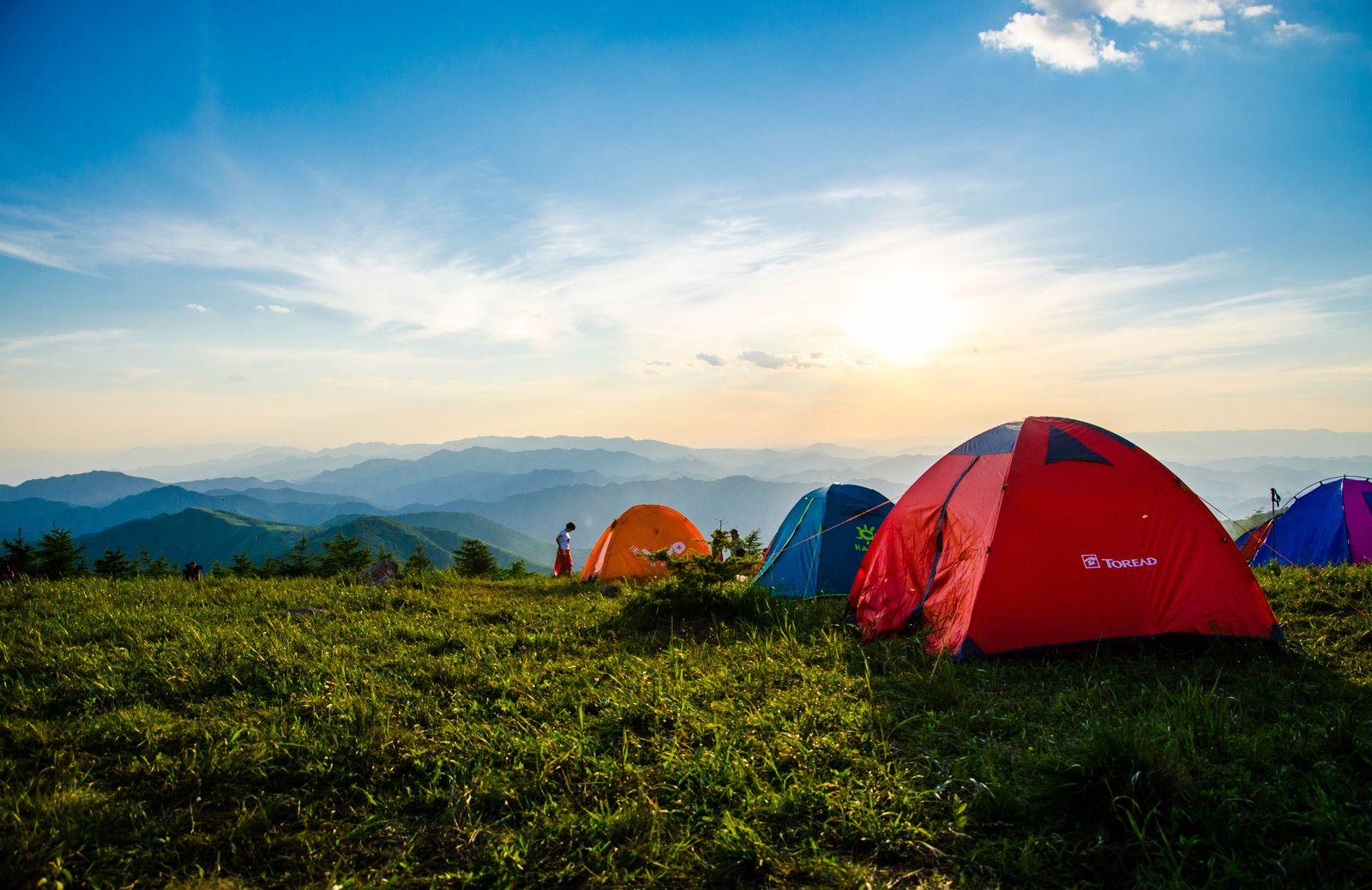 AdventureRoute guide leading group across alpine ridge with mountain panorama